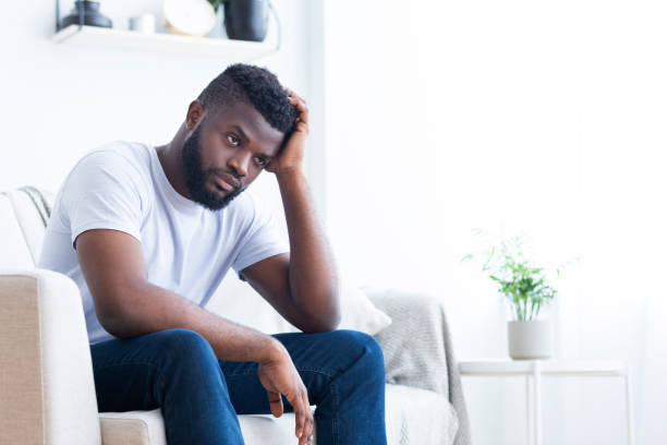 istock Young black man drinking alcohol at home feeling lonely 1161155107