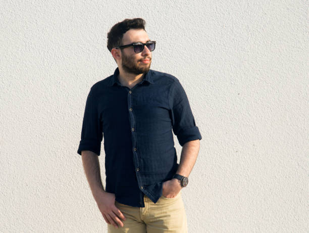 istock young man with hands in pocket looking away 1161157468