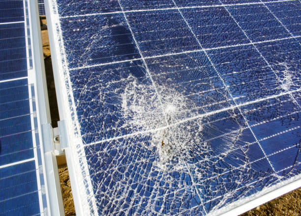 Broken destroyed cracked hole in solar panel stock photo