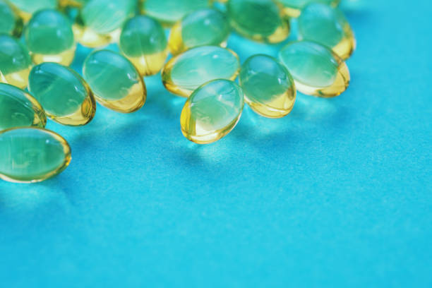 istock Yellow nutritional supplement pills on a blue background 1161160268