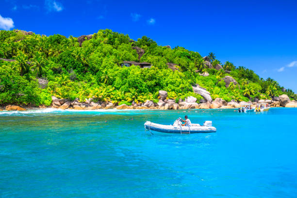 Felicite Island, Seychelles - May 3, 2019: sailboat, motorboat and snorkelers at Felicite Island Marine Park. Granite bloulder stone and turquoise clear sea landscape. Tropical snorleling destination.
