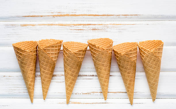 Flat lay ice cream cones collection on white wooden background . Blank crispy ice cream cone with copy space for sweets menu design.