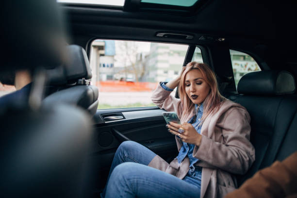 istock Woman using phone in back seat of a car 1161166146