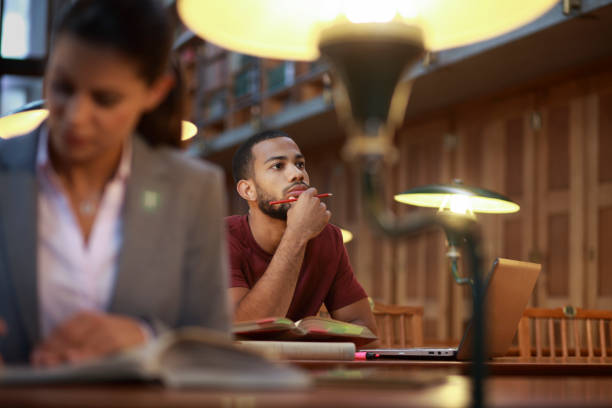 istock Young afro-american man studying in the library 1161167442