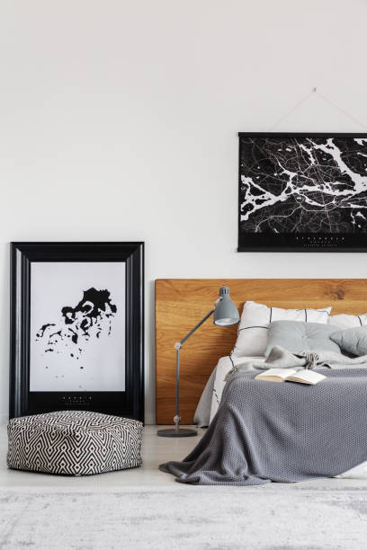 istock Black map on white wall above wooden headboard in simple bedroom interior 1161167944