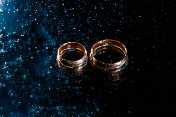 istock Beautiful wedding gold rings on dark background 1161168952
