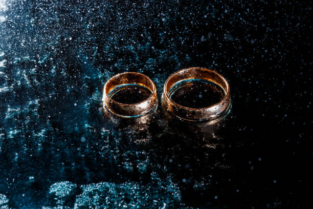 istock Beautiful wedding gold rings on dark background 1161168959