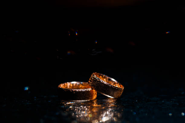 istock Beautiful wedding gold rings on dark background 1161168962