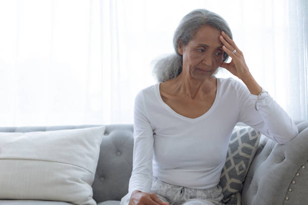 istock Woman sitting on couch 1161170918