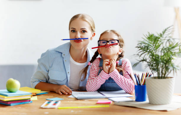 istock funny mother and child daughter doing homework writing and reading 1161170979