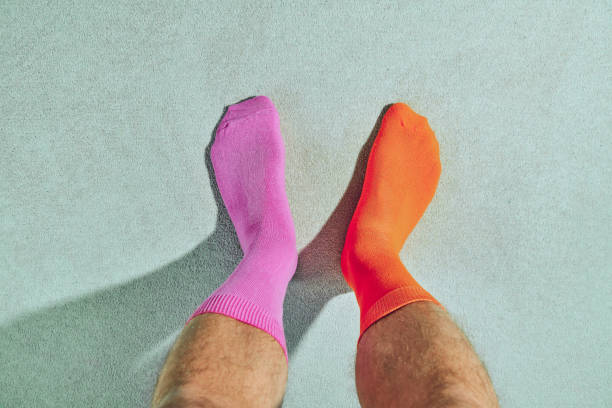 pov ansicht von herrenfüßen tragen seltsame socken, rosa und orange. - diskrepanz stock-fotos und bilder