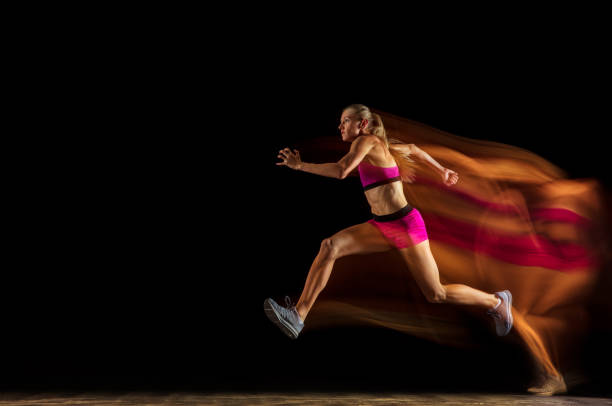 istock Professional female relay racer training on black studio background in mixed light 1161173073