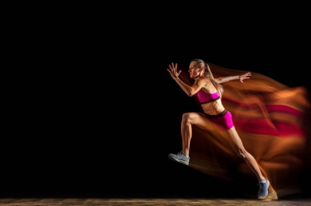 istock Professional female relay racer training on black studio background in mixed light 1161173075