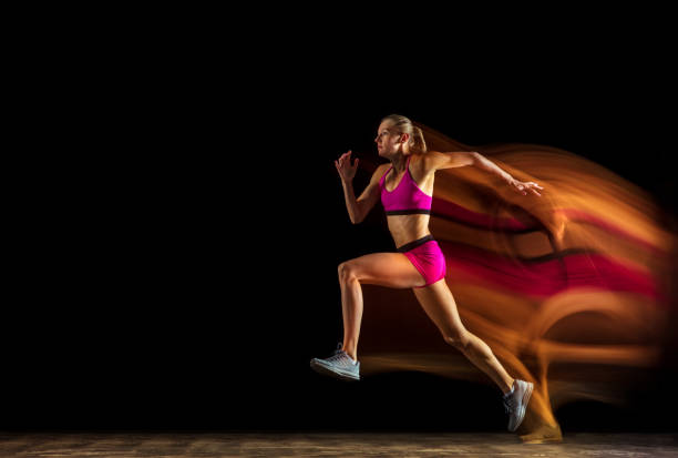 istock Professional female relay racer training on black studio background in mixed light 1161173076