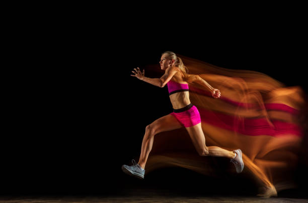 istock Professional female relay racer training on black studio background in mixed light 1161173078