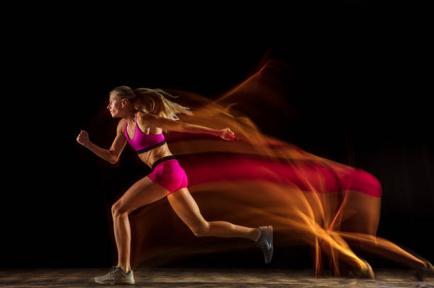 istock Professional female relay racer training on black studio background in mixed light 1161173079