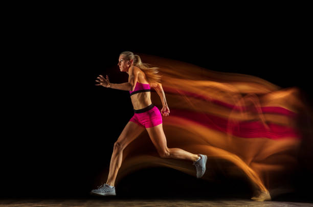 istock Professional female relay racer training on black studio background in mixed light 1161173087