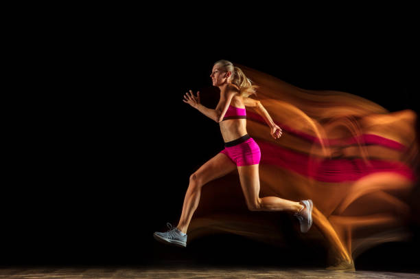 istock Professional female relay racer training on black studio background in mixed light 1161173089