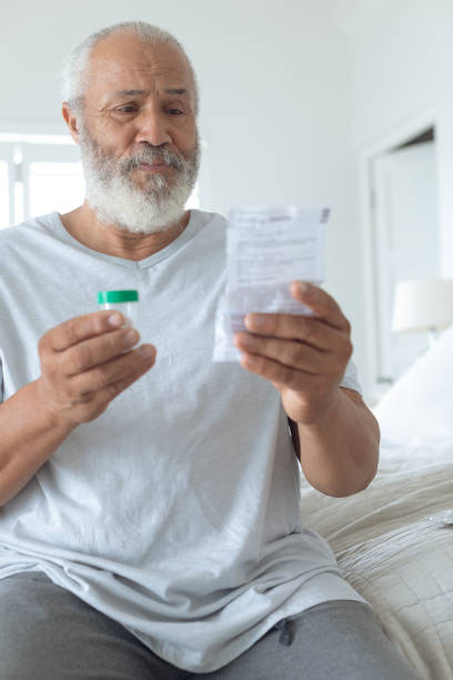 istock Man sitting on the bed while reading through the prescription 1161173826