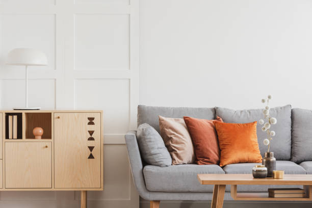istock Vintage wooden commode next to grey Scandinavian sofa with pillows 1161176472