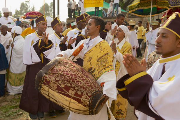 i sacerdoti etiopi celebrano il festival religioso ortodosso timkat suonando musica e ballando per strada ad addis abeba, in etiopia. - dancing africa ethiopian culture ethiopia foto e immagini stock