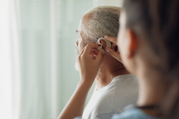 istock Healthcare worker putting hearing aid 1161178097