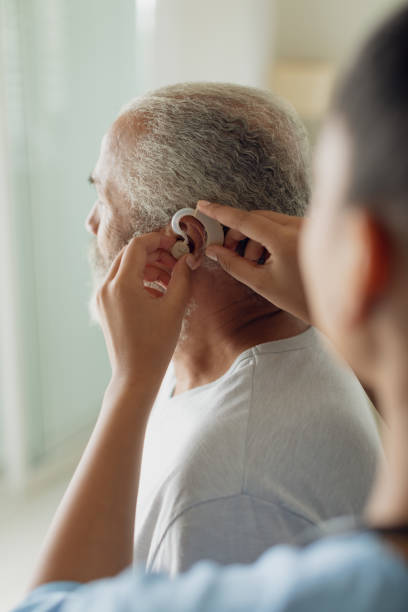 istock Healthcare worker putting hearing aid 1161178142