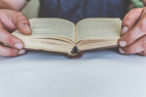 istock man reading a book at the table, having a snack while reading, a short break 1161181905