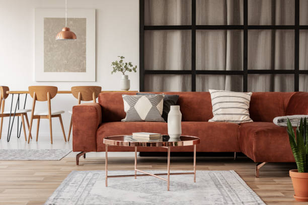 elegante divano ad angolo marrone con cuscini a motivi geometrici in eleganti interni del soggiorno con pareti di montanti - mullions foto e immagini stock
