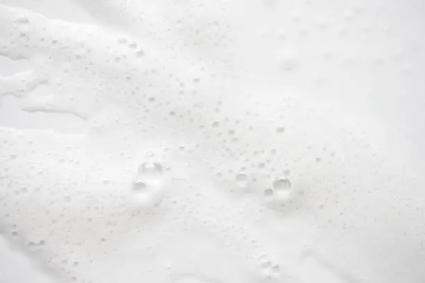 Photo of Abstract background white soapy foam texture. Shampoo foam with bubbles