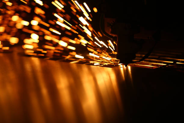 Industrial laser machine for metal cutting. Orange sparkles blurred background