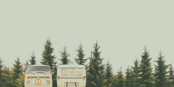 A vertical shot of a retro vintage RV parked in a dense forest during a holiday trip