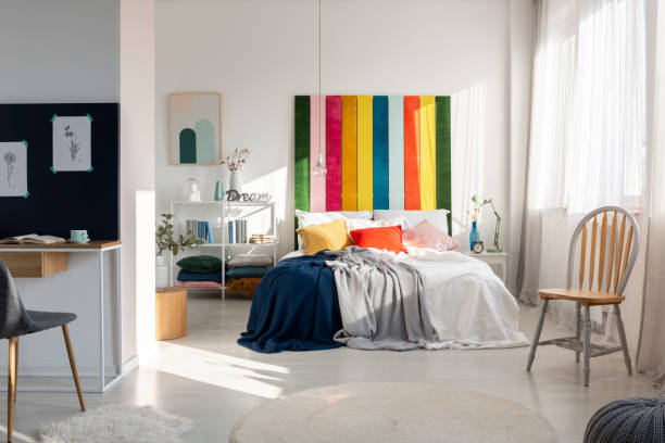 Fashionable bedroom interior with colorful headboard, king size bed, chair and workspace Fashionable bedroom interior with colorful headboard, king size bed, chair and workspace red cushion covers stock pictures, royalty-free photos & images