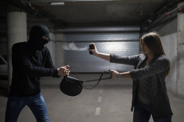 mujer usando spray de pimienta para la autodefensa contra el ladrón - pulverizador de pimienta fotografías e imágenes de stock