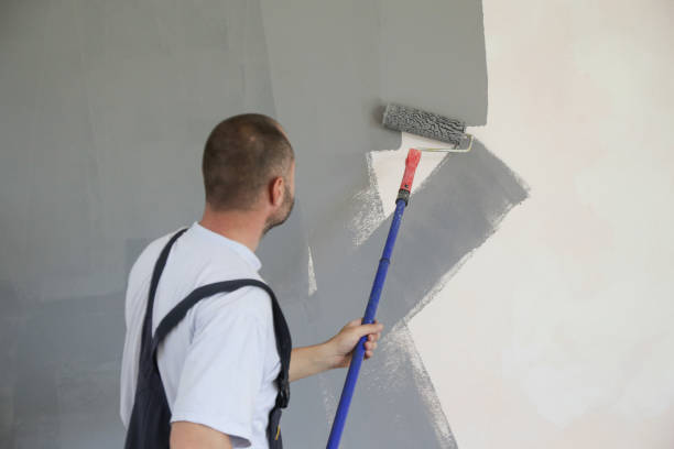 istock Man painting with gray paint over a white wall 1161185298