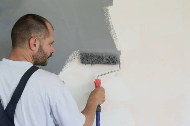 istock Man painting with gray paint over a white wall 1161185401