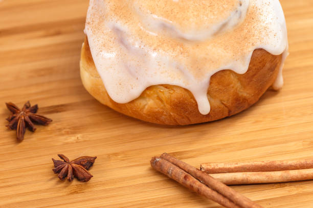 Russian traditional rum baba, sweet cake with raisins, nuts and cinnamon on a wooden plate