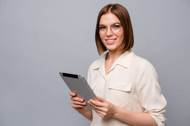 istock Close up side profile photo beautiful attractive she her business lady chief e-reader hands arms reader data startup novelty interested curious wear specs casual white shirt isolated grey background 1161188142
