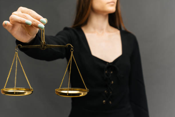 istock Serious woman holding the justice scale on dark background 1161189381