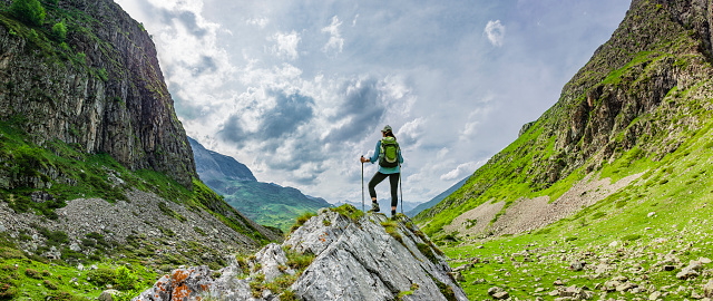 Woman with backpack while hiking in mountains