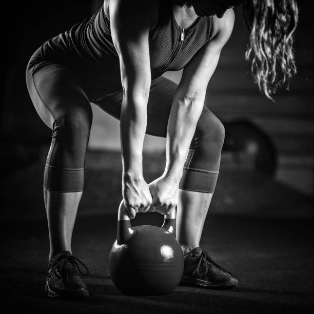 atleta donna che si allena con kettlebell - picking up weight women sport foto e immagini stock
