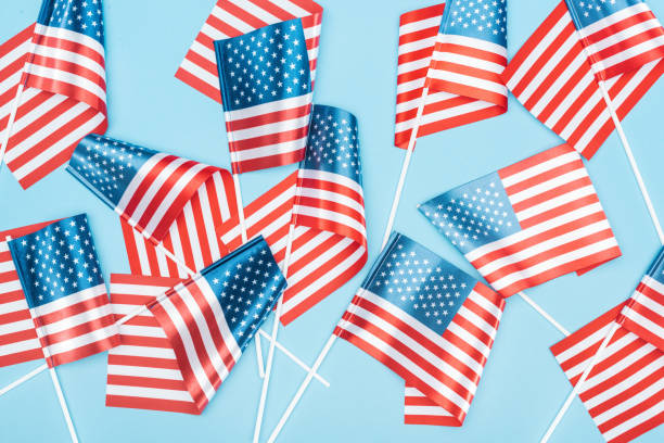 istock top view of american flags on sticks scattered on blue background 1161191579