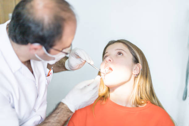 Male dentist with male patient in his clinic.