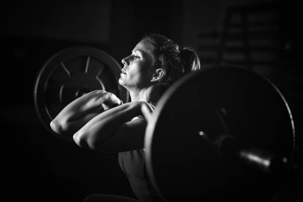 sollevamento pesi donna in allenamento - picking up weight women sport foto e immagini stock