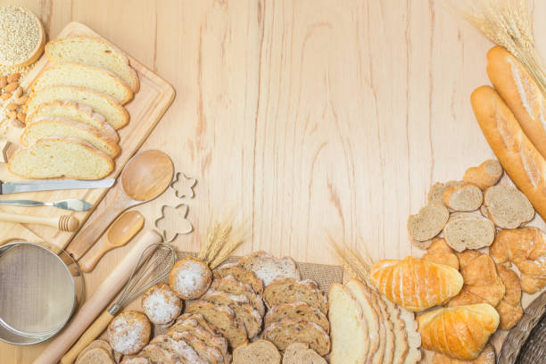 Homemade bread or bakery with rolling pin, whisk, spoon and bakery equipment on wooden background, top view with copy space.