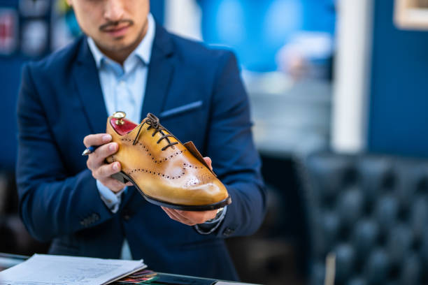 Well-dressed   Chinese salesman working in luxury shoes store at the shopping mall