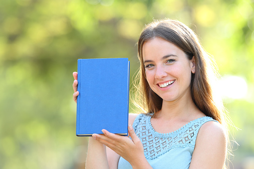 Happy woman showing a blank book cover