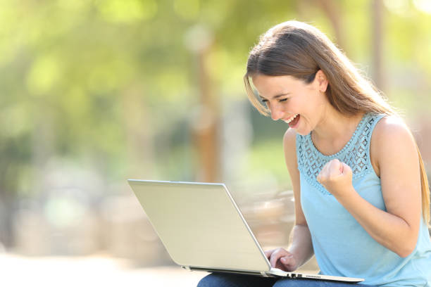 Excited woman checking laptop celebrating good news Excited woman checking laptop celebrating good news personal loan stock pictures, royalty-free photos & images