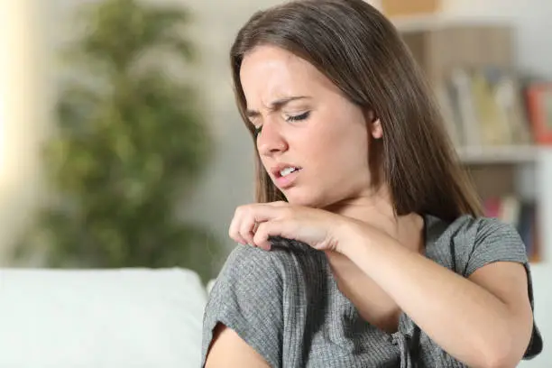 Woman suffering itching scratching shoulder