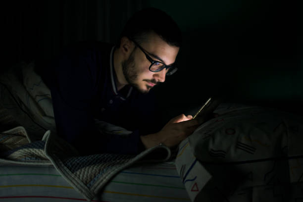 istock Man looking his mobile phone in the bed at night 1161201001